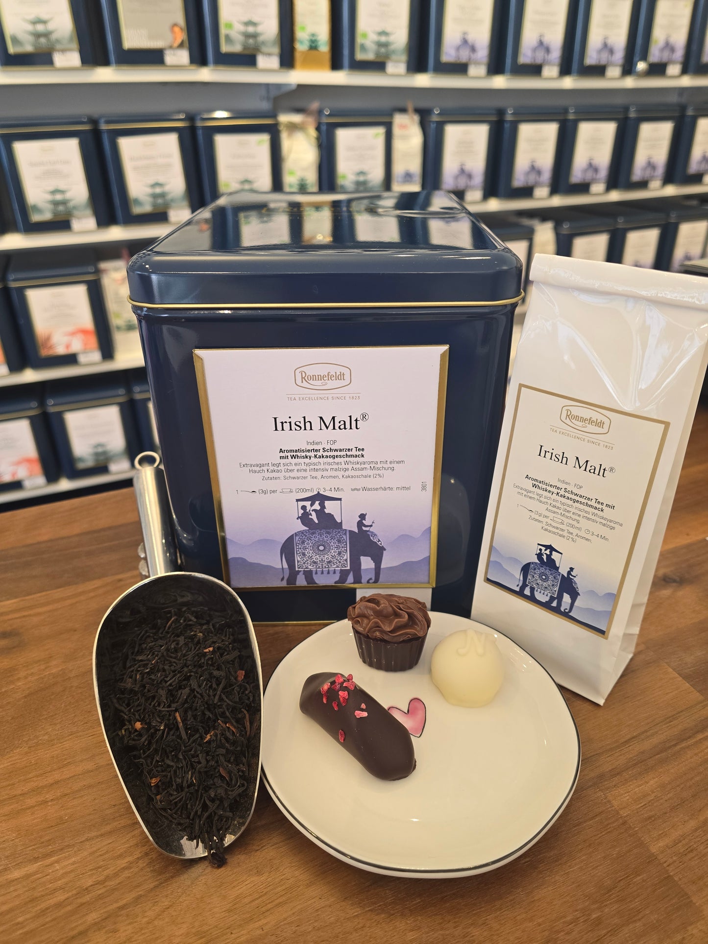Edles Tee-Präsent mit aromatischem Schwarztee „Irish Malt“ in loser und verpackter Form, kombiniert mit feinen Pralinen – ideales Geschenk für Teeliebhaber:innen, Genussmenschen und Kund:innen, die Wert auf hochwertige Feinkost legen
